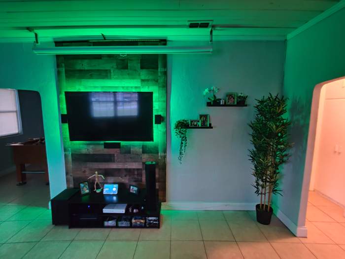 Mounted TV with backlit wood accent wall