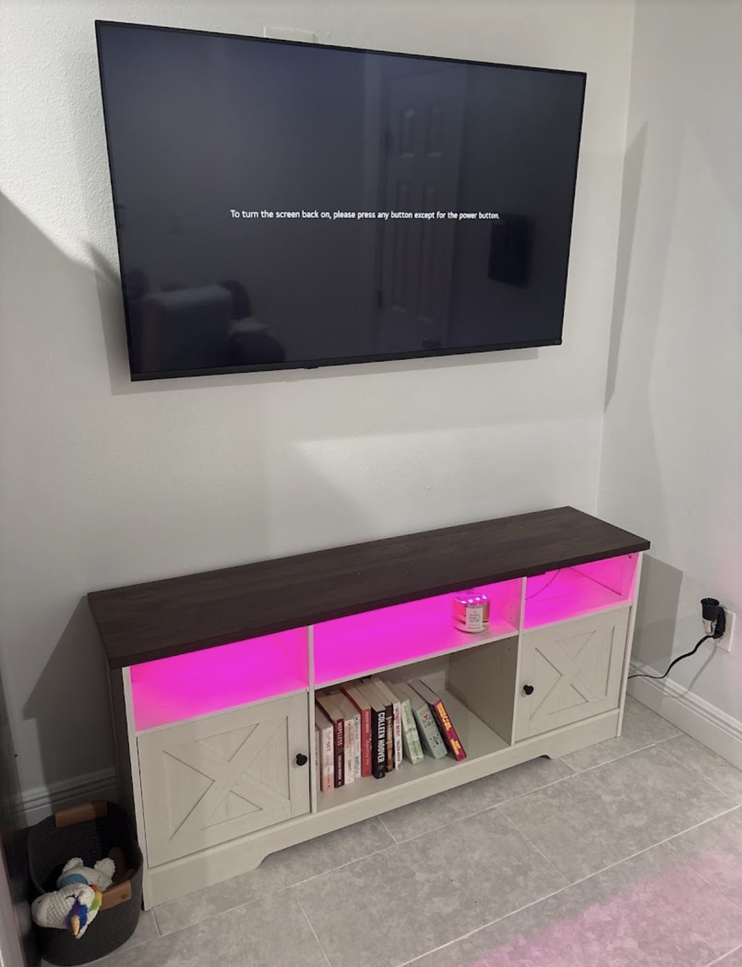 Wall-mounted TV above a media console with color-changing LED accent lighting