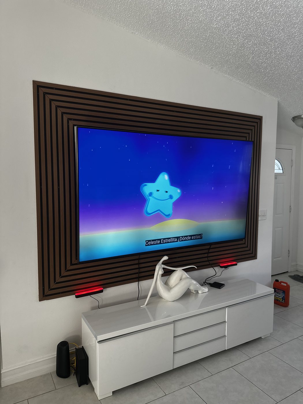 Wall-mounted TV framed with a custom wood wall accent